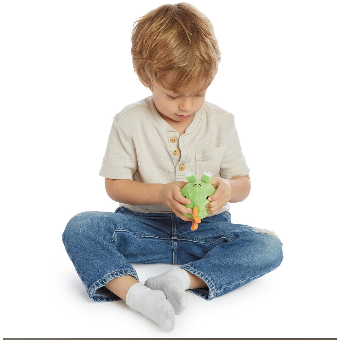 Suggestion
Child holding a green plush toy on a white background