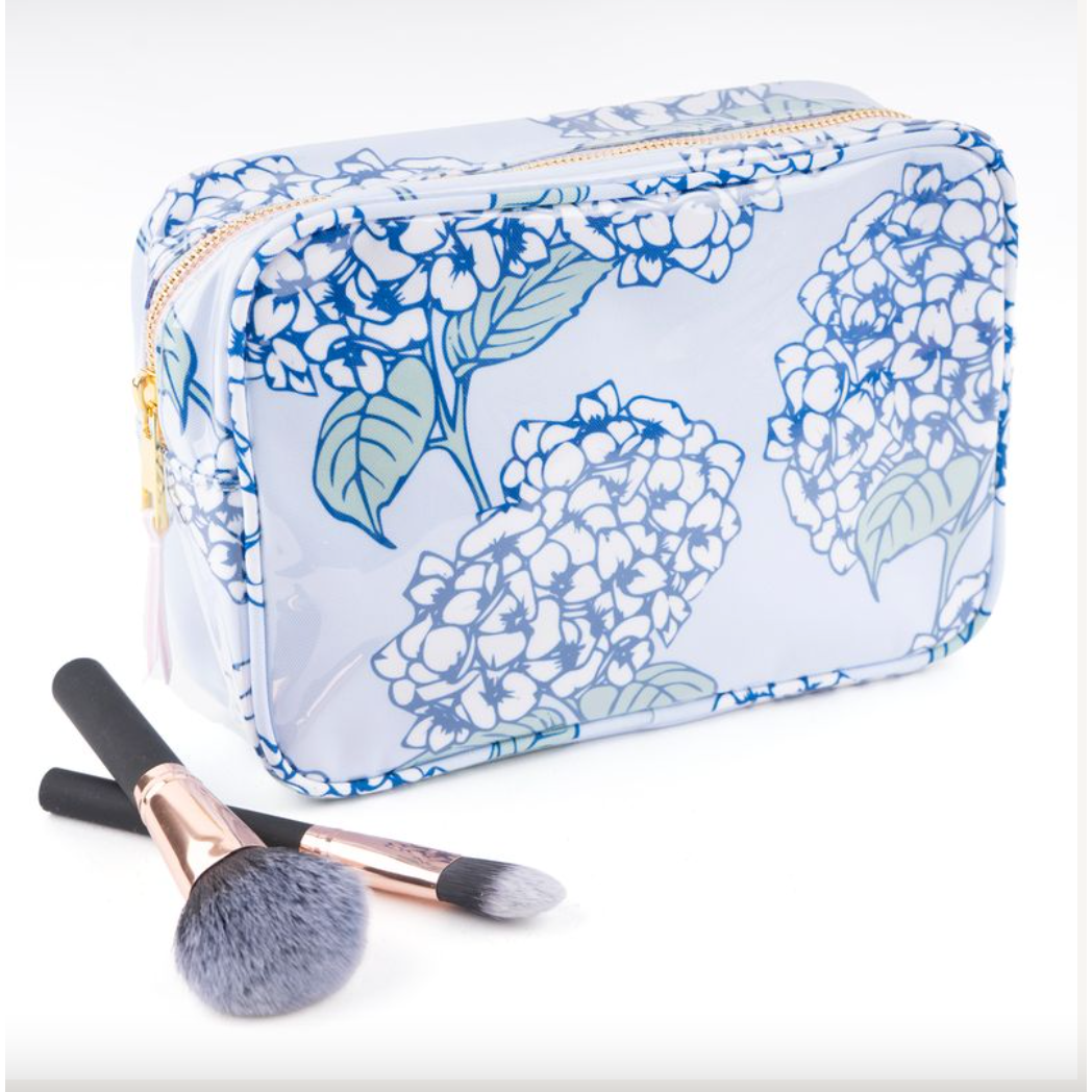 Floral-patterned cosmetic bag with makeup brushes on a white background