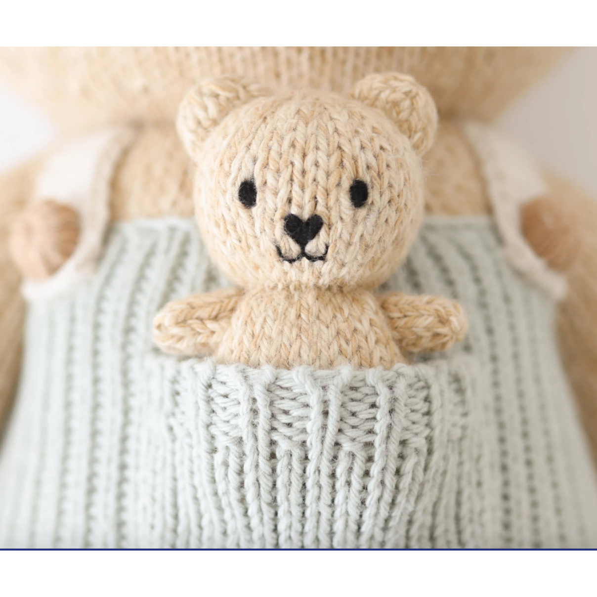 Knitted teddy bear toy in a basket with a soft focus background