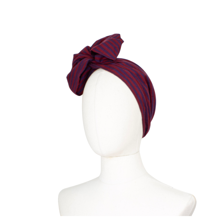 A dark red and navy blue striped fabric headwrap styled on a white mannequin head against a plain white background.