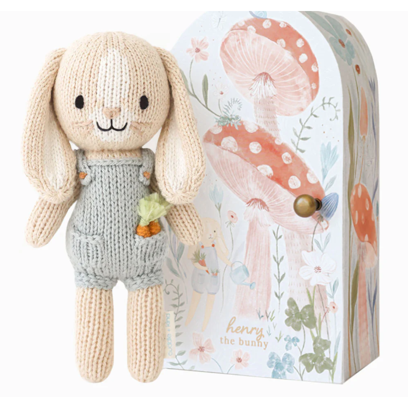 Knitted bunny toy with a decorative box featuring floral designs.