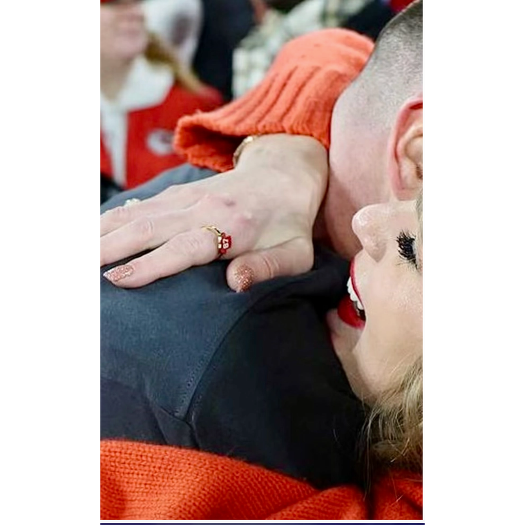 Close-up of a hand with a ring on a person wearing an orange garment.