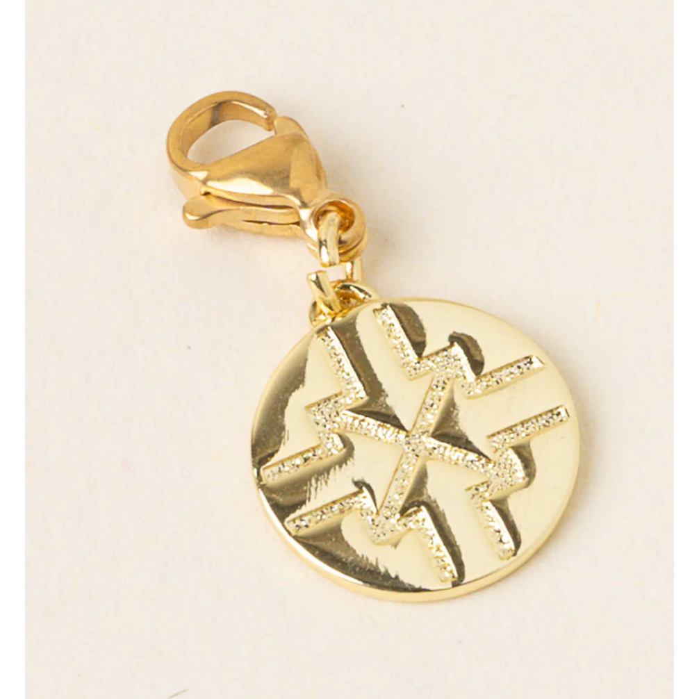 Gold pendant with star design on a beige background