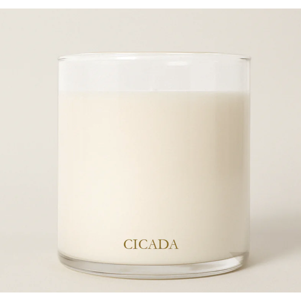 Candle with 'CICADA' branding on a light background