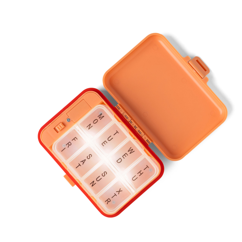 Orange pill organizer with days of the week labels on a white background