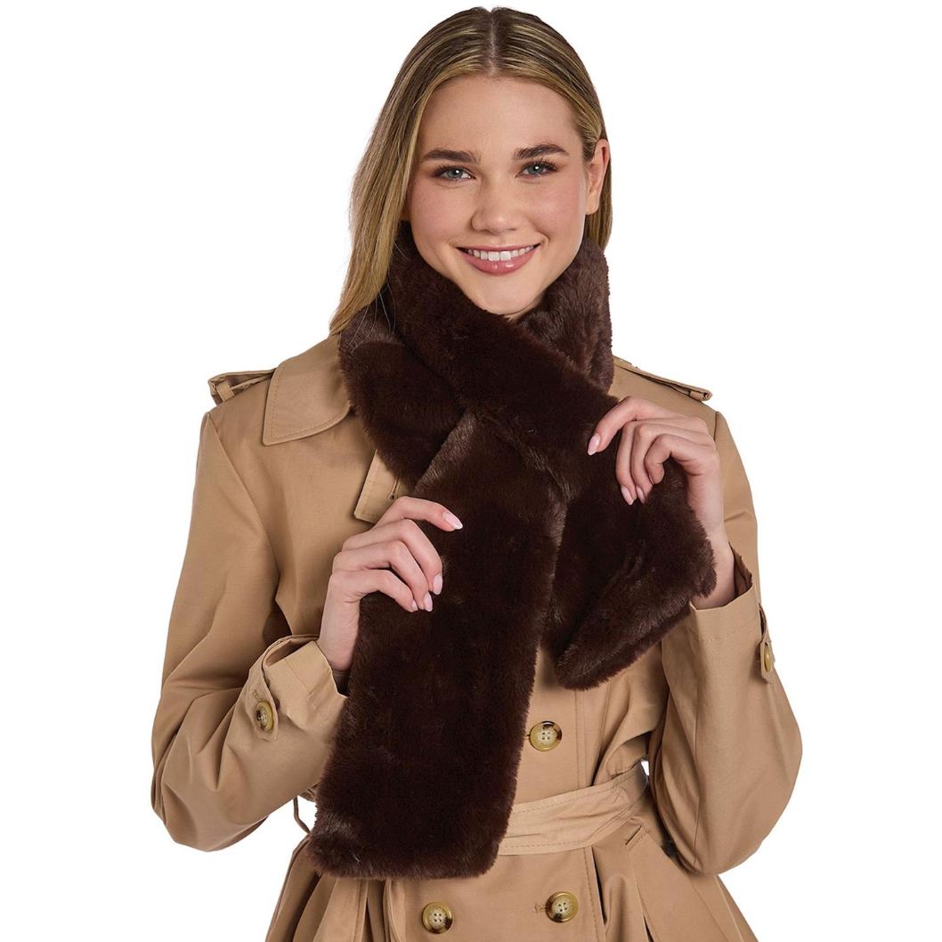 Woman wearing a tan coat with a brown fur scarf on a white background