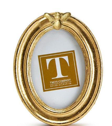 Gold oval picture frame with a butterfly design on a white background