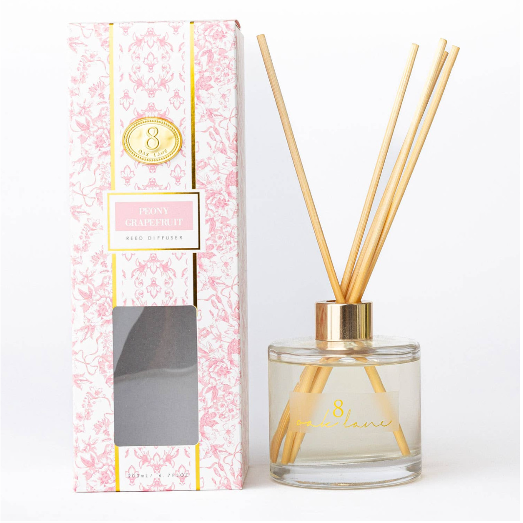 Reed diffuser with floral packaging on a white background