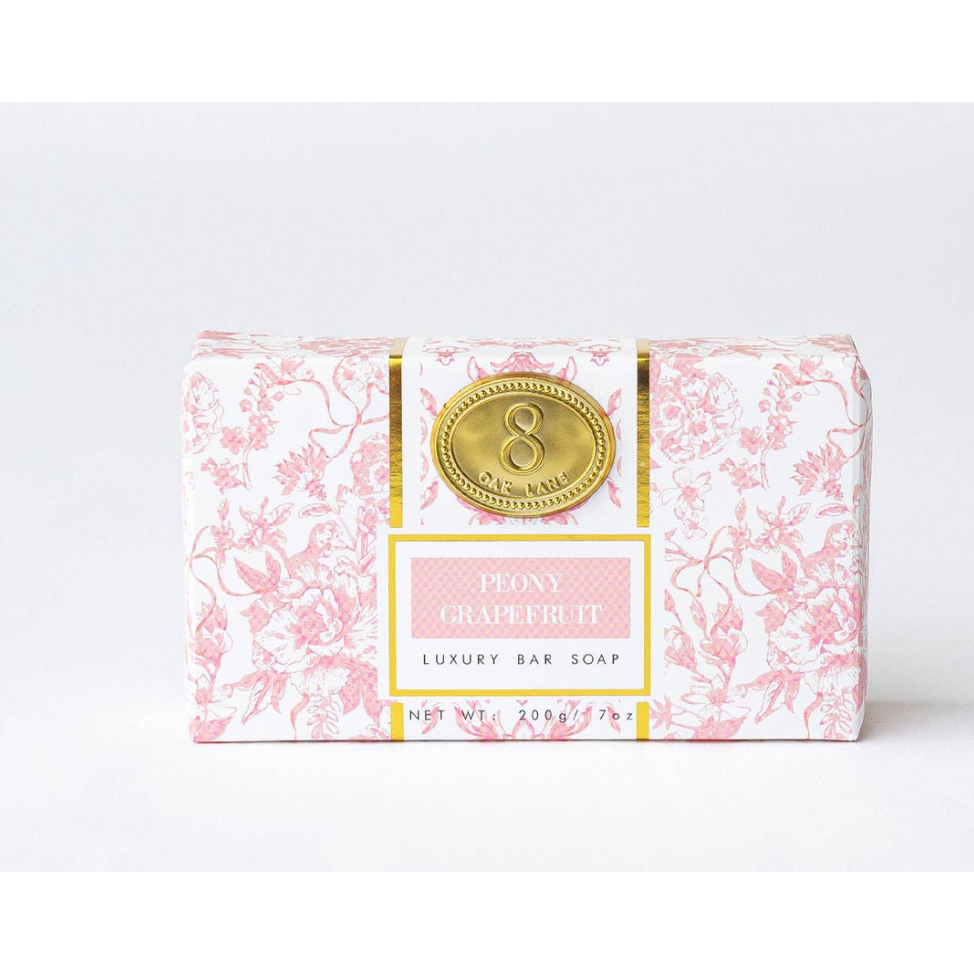 Bar of soap with decorative packaging featuring a floral design and gold emblem on a white background.