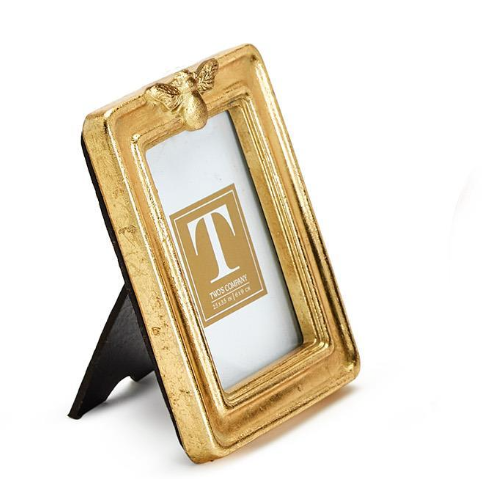 Gold picture frame with a decorative butterfly on a white background