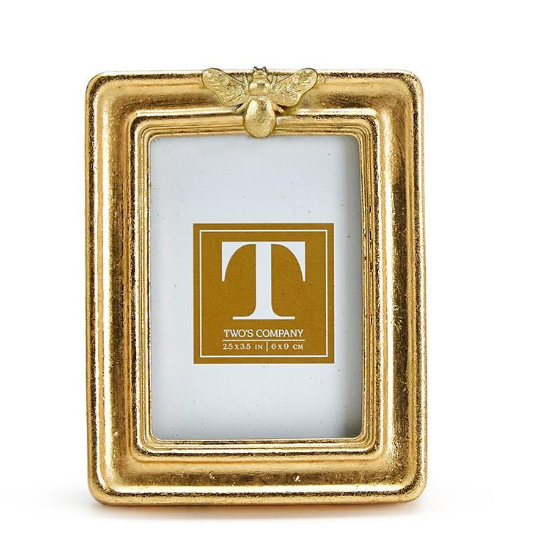 Gold picture frame with a decorative bee on a white background