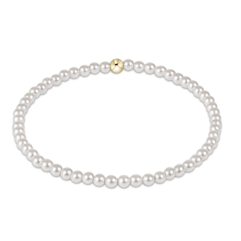 A single-strand pearl necklace with a small gold accent bead at the top center, displayed on a clean white background.