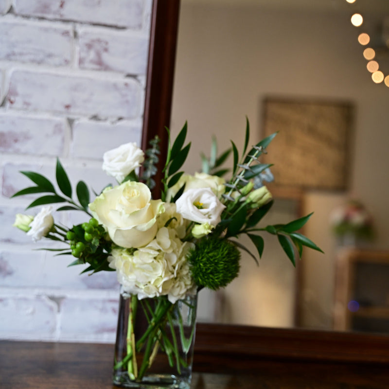 Green and White Bouquet with roses, hydrangeas, lisianthus, and greenery in a clear vase from White Farmhouse Flowers Parkville MO