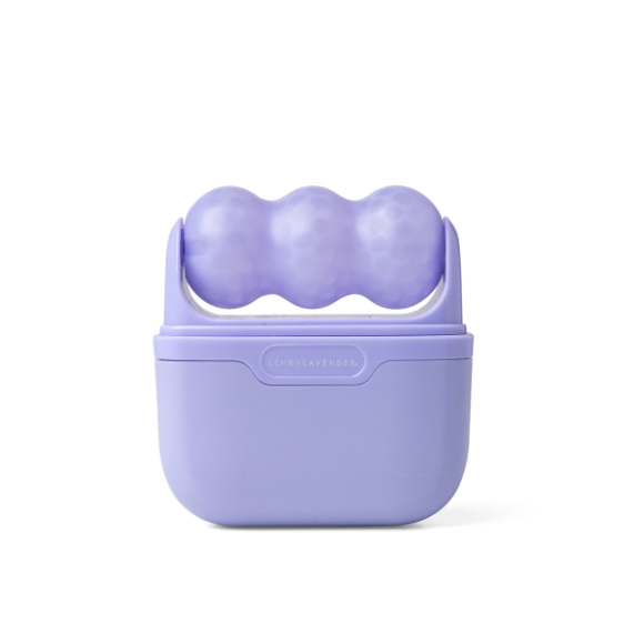 A lavender purple silicone massage roller with three rounded textured balls on top of a matching lavender plastic carrying case, shown on a clean white background.