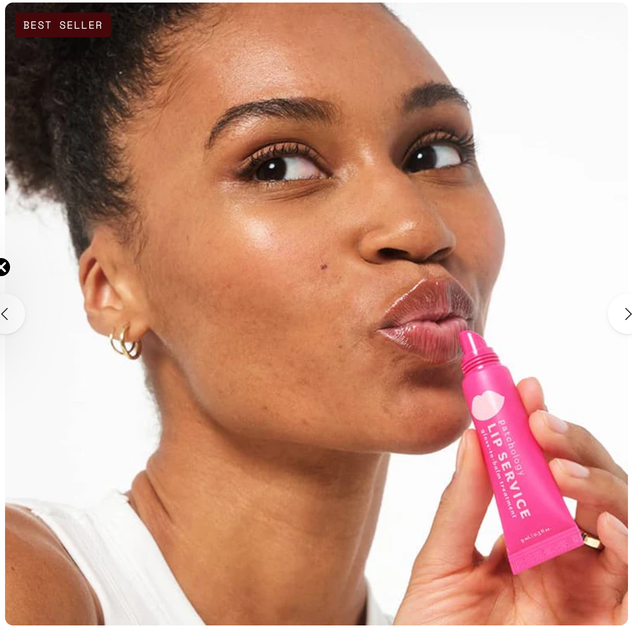 Woman applying pink lip balm to her lips with a white background