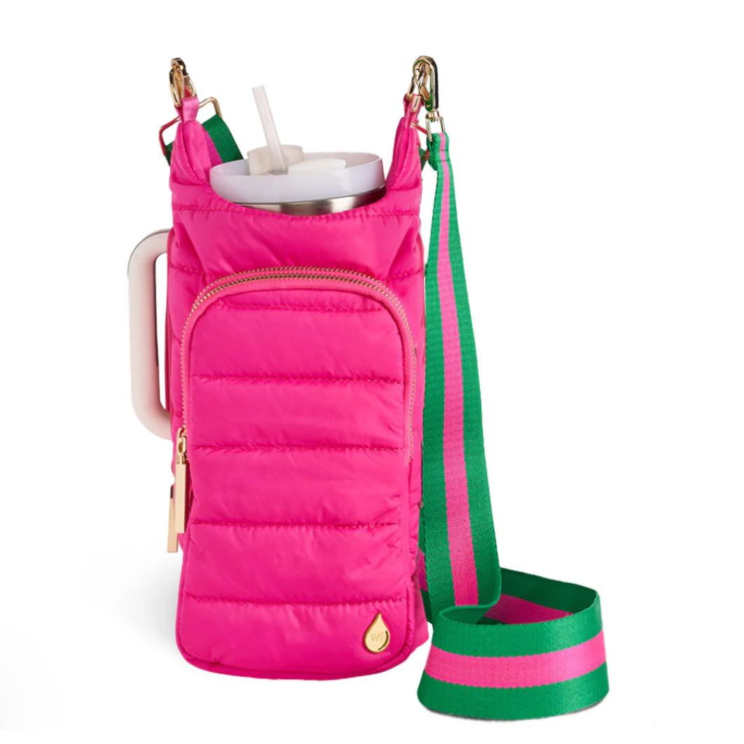 Pink insulated drink holder with green strap on a white background