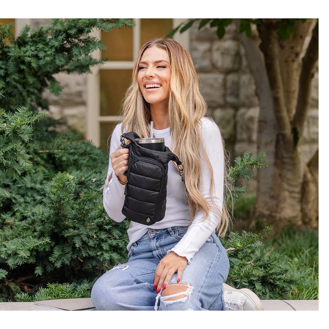 Woman holding a black insulated cup holder outdoors