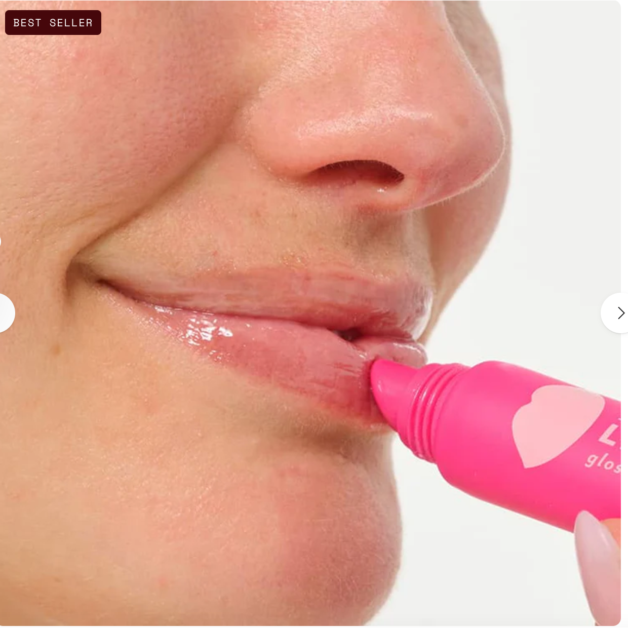 Close-up of a person applying pink lip gloss to their lips with a visible brand logo.