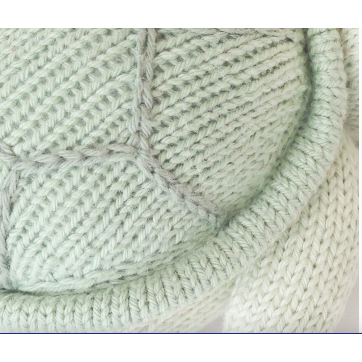 Close-up of light green knitted fabric with a textured pattern