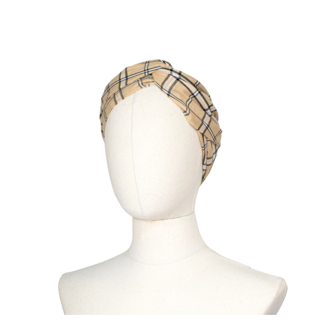 A beige plaid headband with black and white stripes, displayed on a white mannequin head against a plain white background.