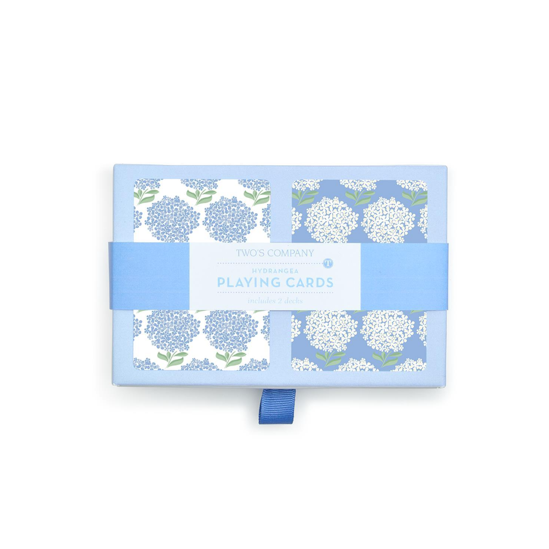 Playing cards with floral design on a blue box against a white background