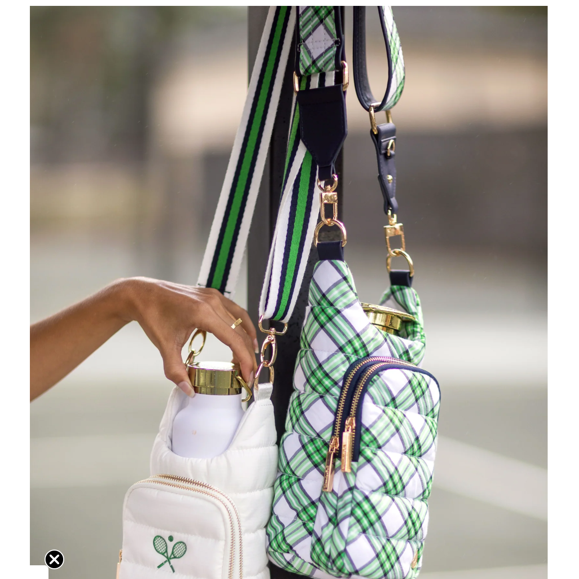 Green plaid handbag with a white pouch held by a hand against a blurred background
