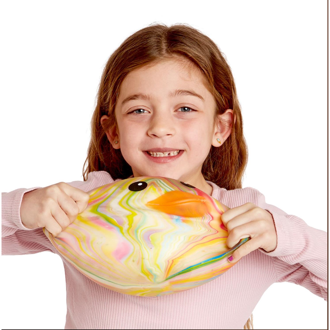 Young girl holding a colorful fish-shaped object against a white background