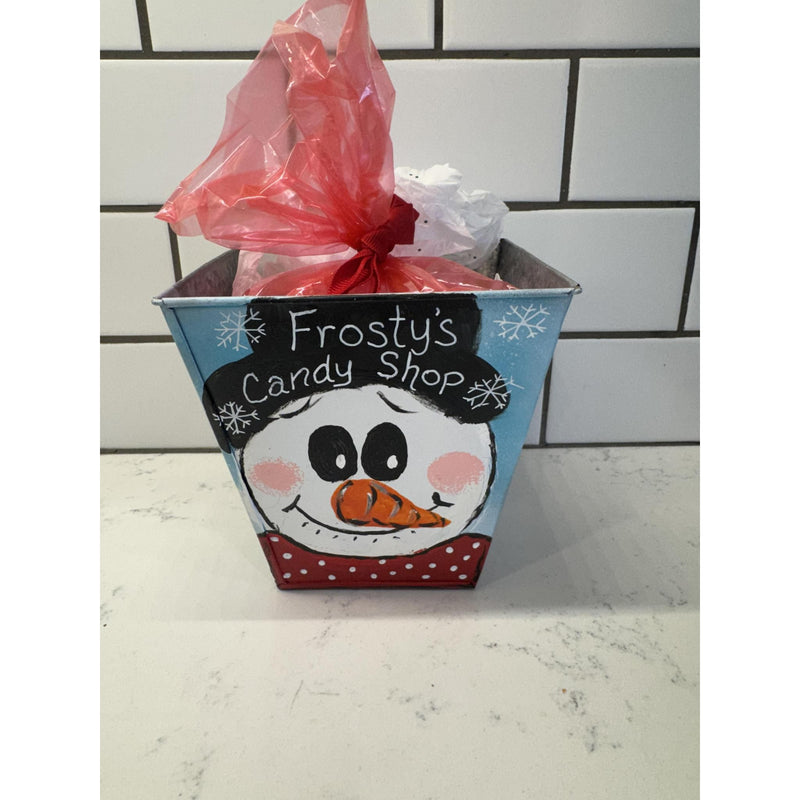 Decorative candy container with a snowman design and red bow on a white surface.