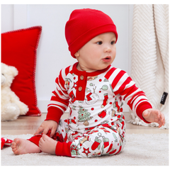 Baby wearing a red and white Christmas-themed outfit with a matching hat.