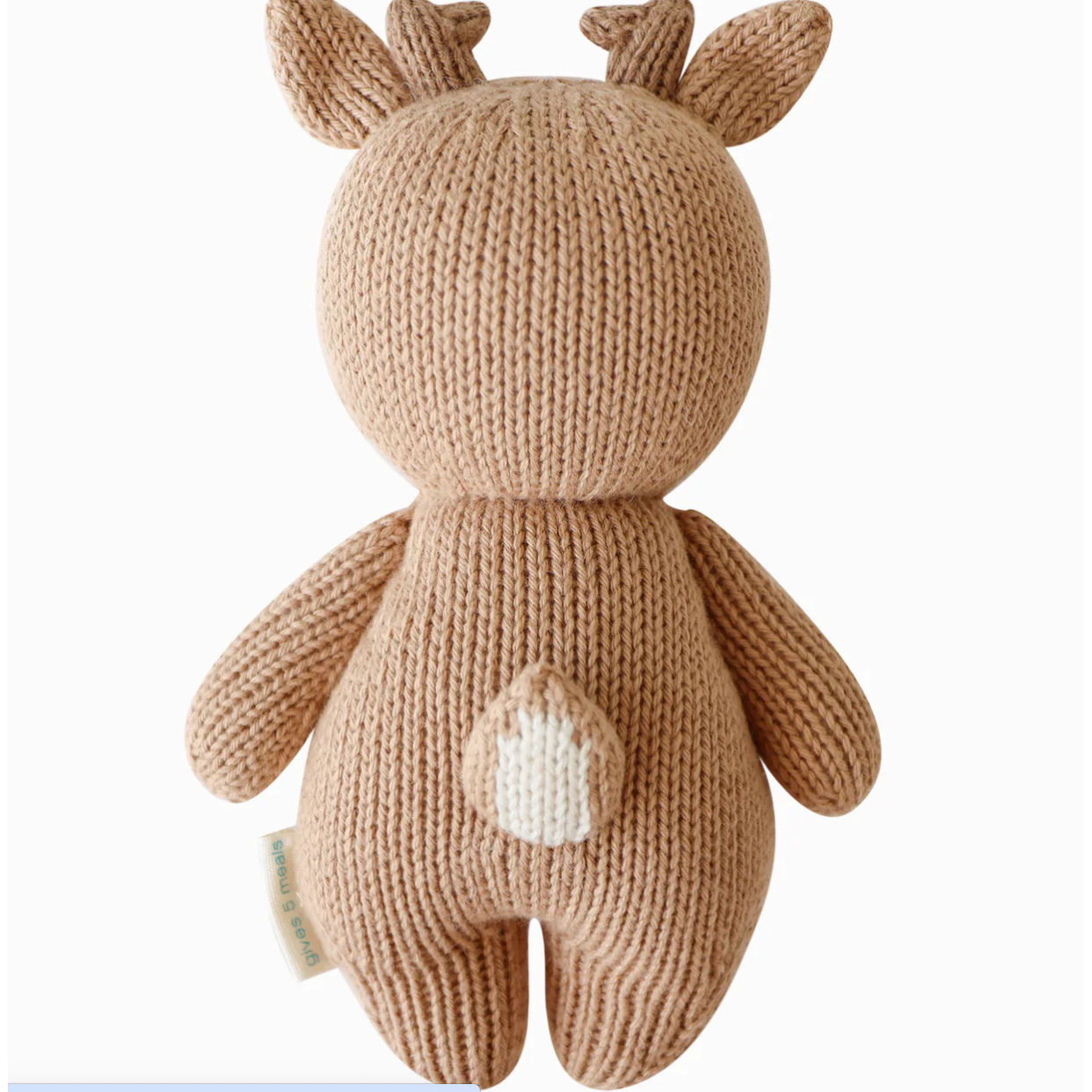 Knitted toy deer with a white patch on a beige background