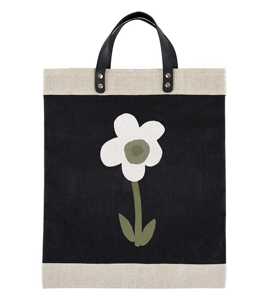 Black tote bag with a white flower design on a white background