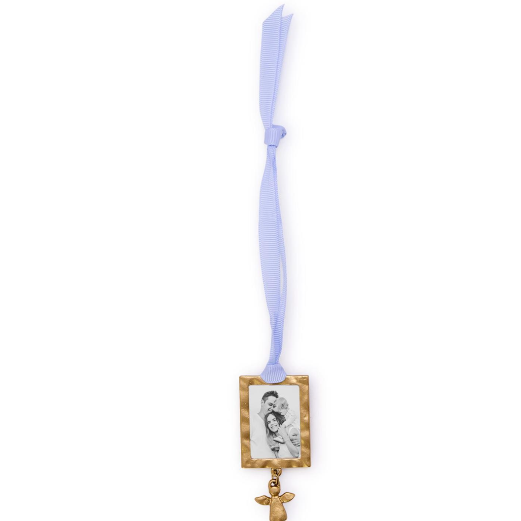 Decorative ribbon with a photo frame and a small angel figurine on a white background