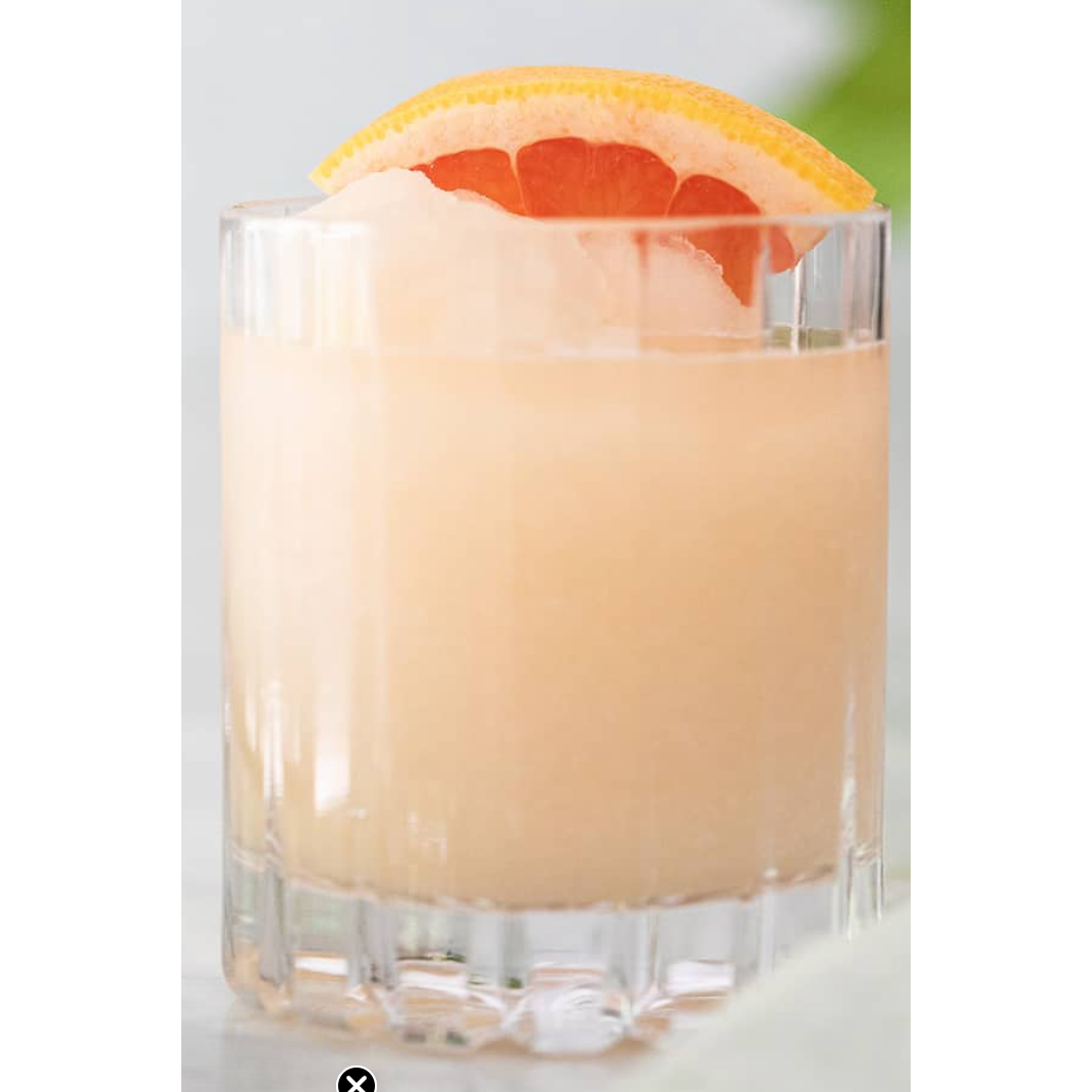 Cocktail in a glass with a grapefruit slice on a light background