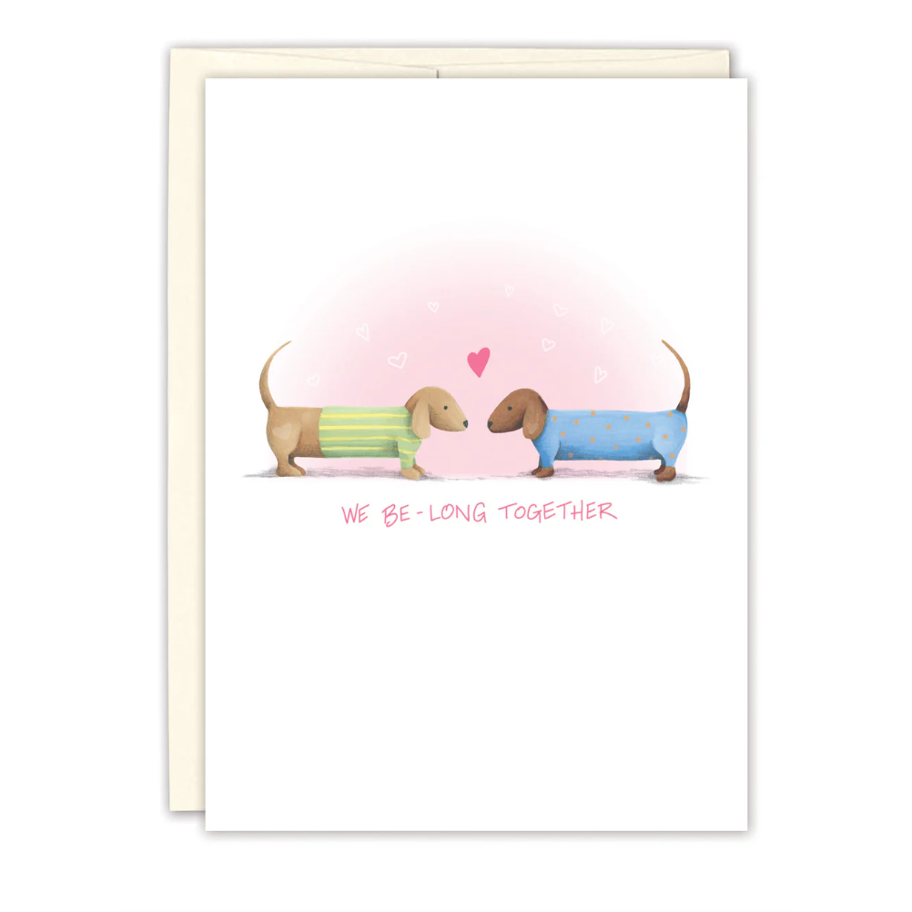 Card with two cartoon dogs sitting together on a heart, with 'We be-long together' text.