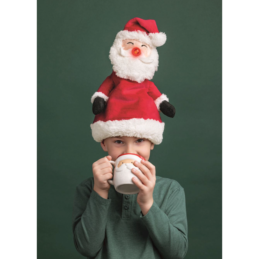 Child wearing a Santa Claus hat with a green background