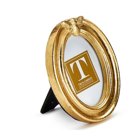Gold decorative ring with a 'T' logo on a white background