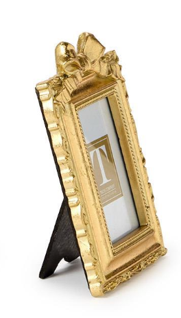 Gold ornate picture frame with a stand on a white background