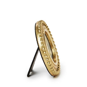 Decorative gold circular object on a stand against a white background