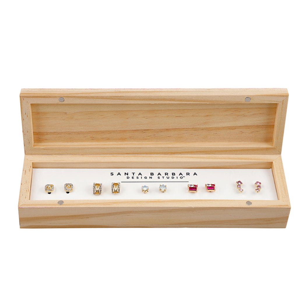 Set of earrings in a wooden box with 'Santa Barbara Design Studio' branding.