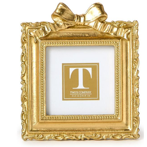 Gold decorative picture frame with a bow on a white background