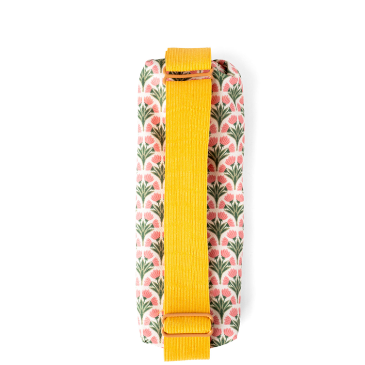 A close-up of a fabric bag or pouch with a pink and green floral pattern on a white background, featuring a prominent mustard yellow strap.