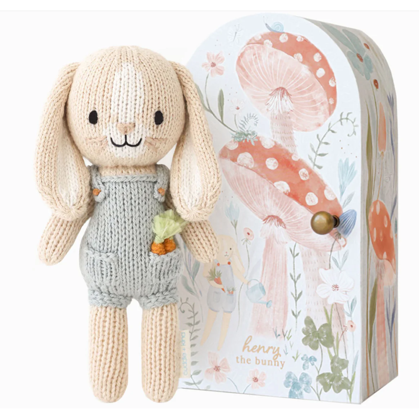 Knitted bunny toy with a decorative box featuring floral designs.