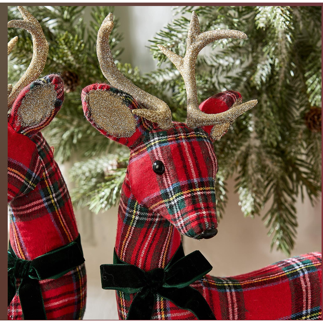 Red plaid deer ornaments with gold antlers on a Christmas tree.