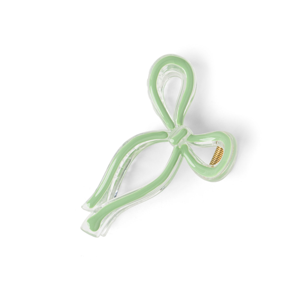 Green hair clip with a bow design on a white background