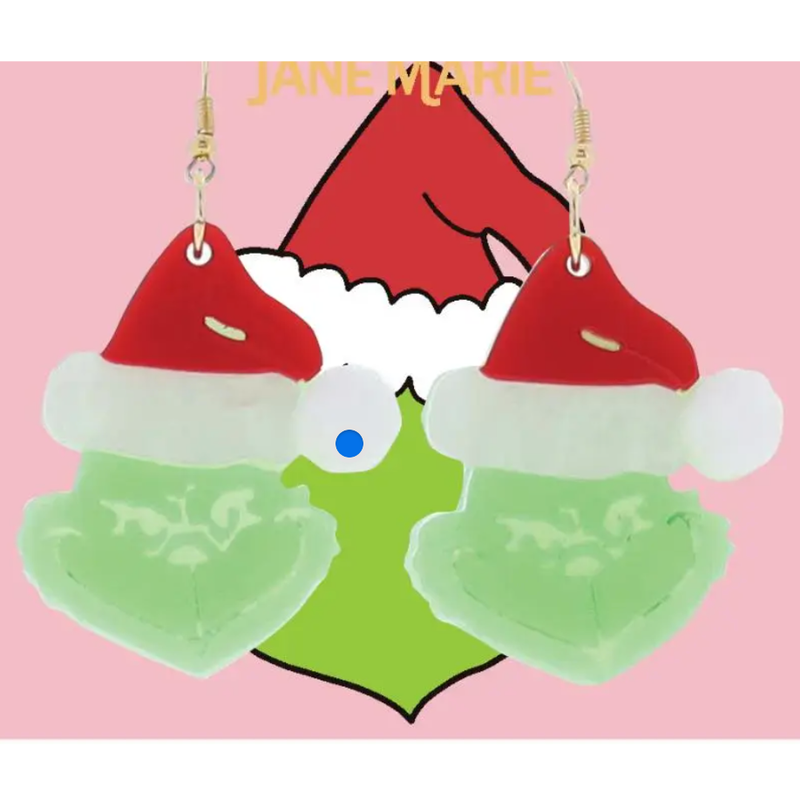 Earrings shaped like a cartoon character with a red hat and green body on a pink background.