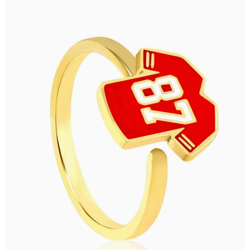 Gold ring with a red heart-shaped pendant featuring the number 87 on a white background