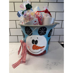 Snowman-themed bucket filled with treats on a kitchen counter