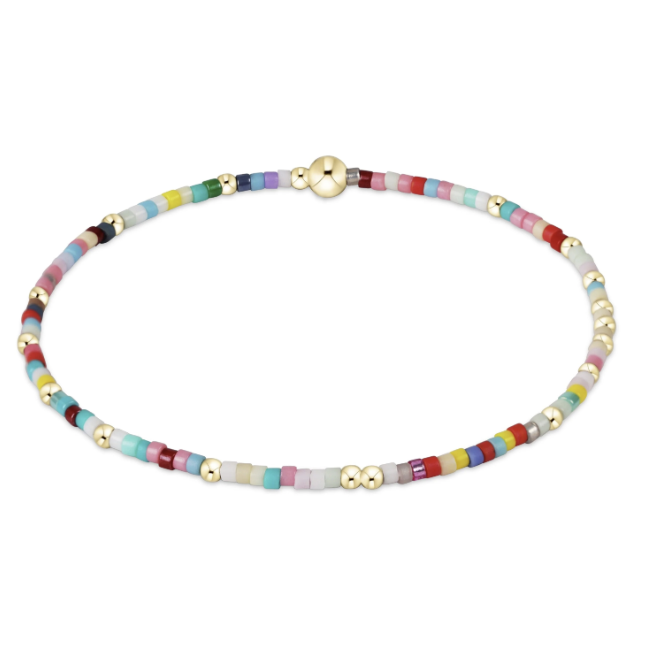 A beaded bracelet with small multicolored cylindrical beads, gold spacer beads, and a gold larger bead shown on a plain white background.
